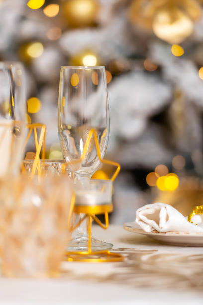 istock New Year's table setting in a photo studio. Plates with glasses on a Christmas tablecloth 2202459693