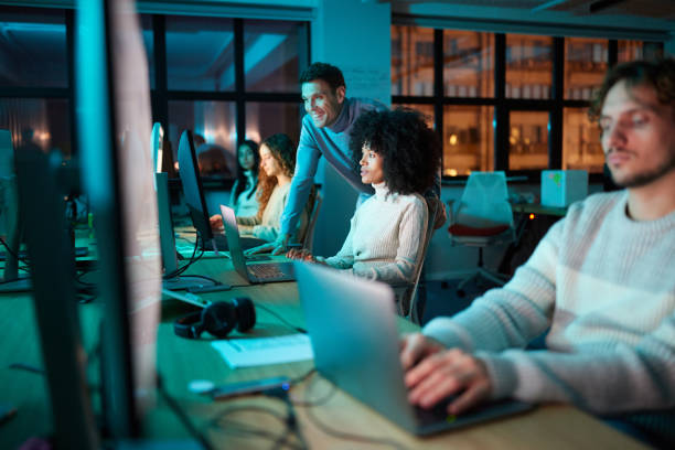istock Diverse graphic designers working on desktop PC late in the office. 2202461131