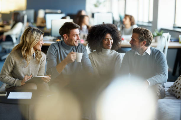 istock Team of happy entrepreneurs talking on sofa at casual office. 2202461872
