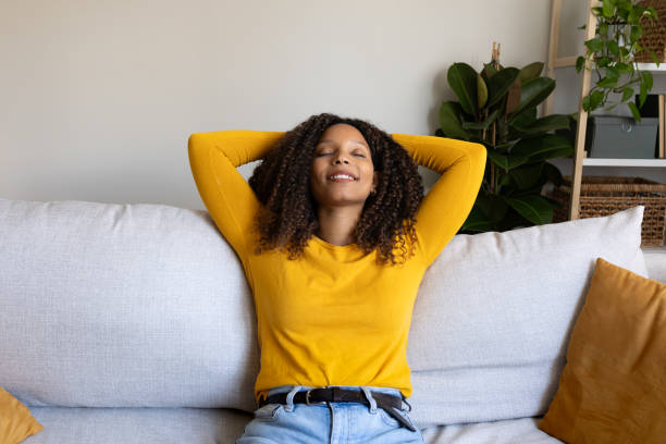 istock Serene young woman relaxing on comfortable sofa at home 2202462492