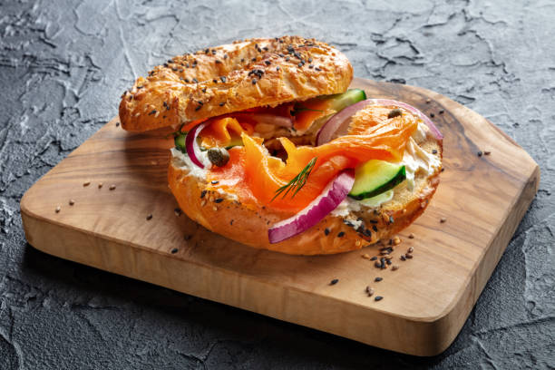 istock Lox bagel. A sandwich with smoked salmon and fresh vegetables 2202463877