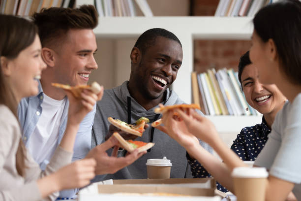 istock Overjoyed multiracial young people have fun eating pizza 2202466093