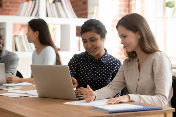 istock Concentrated multiracial female students work together at laptop 2202466260