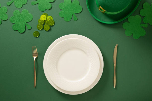 istock St Patrick's Day table setting with white plate and clover leaves on green. 2202466362