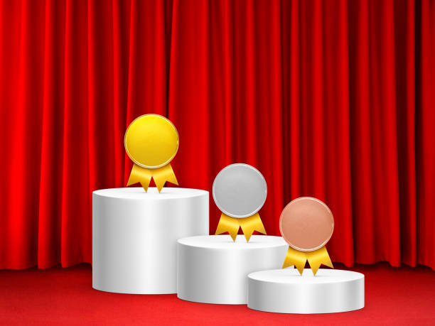Medals on a white podium with a red curtain background.