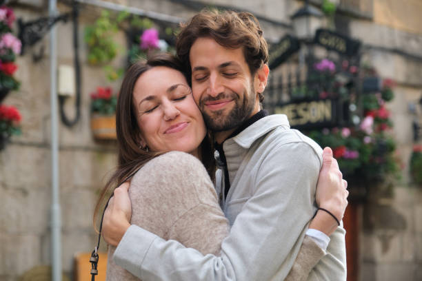 Man and woman hugging with sun flare from behind - Love scene with couple embracing and supporting each other - Lifestyle, love and travel concepts