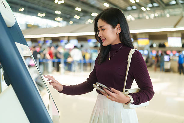 istock A beautiful Asian female passenger is using an automated check-in kiosk to check in for her flight at the airport. 2202467754