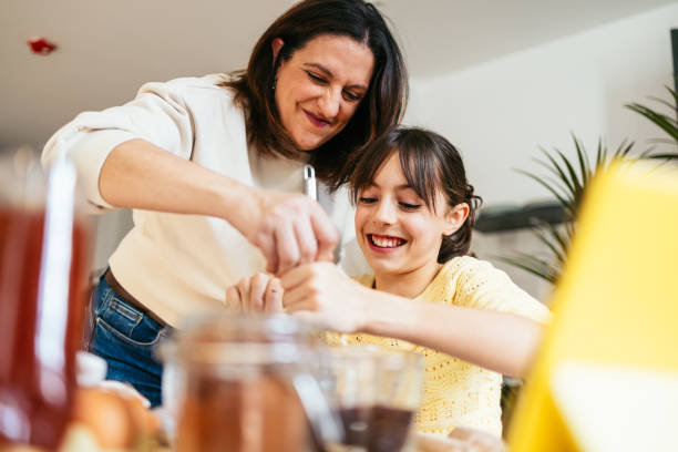 istock Mom and daughter baking chocolate cookies together in modern kitchen 2202468070