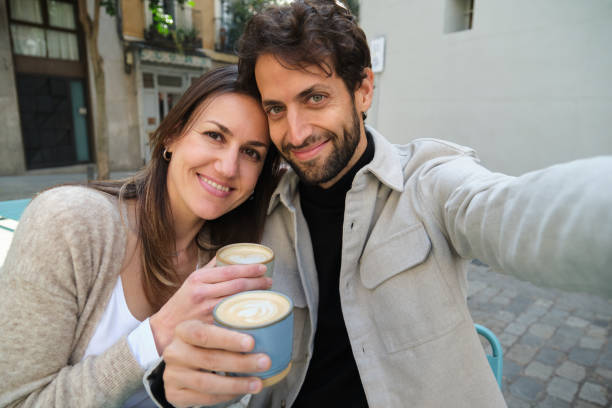 istock Happy couple taking a selfie while enjoying coffee outdoors 2202468291