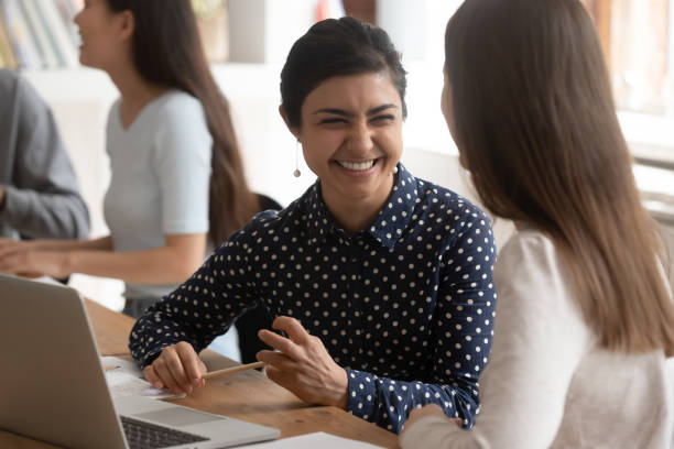 istock Overjoyed multiethnic female students laugh cooperating at project 2202468322