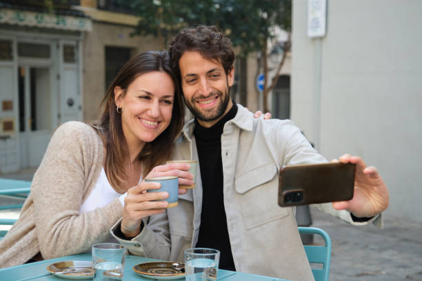 istock Happy couple taking a selfie while having coffee at outdoor cafe 2202468339