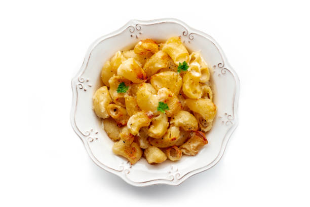 Mac and cheese, the classic pasta with macaroni and Cheddar cheese, baked in the oven, overhead flat lay shot on a white background