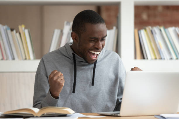 istock Overjoyed african American guy get positive email on laptop 2202468671