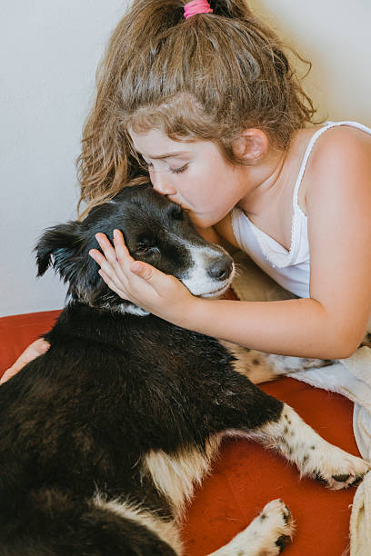 istock Child hugging her black adopted dog 2202469097