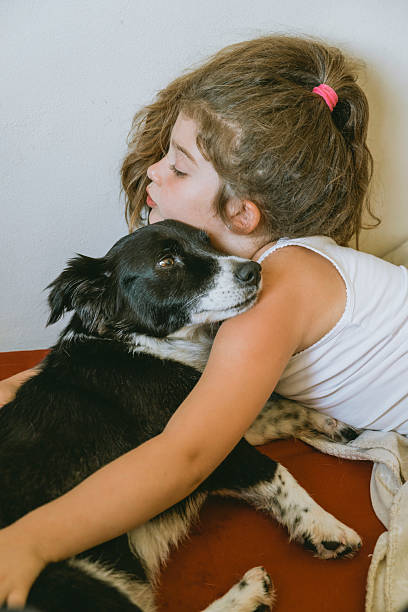 istock Child hugging her black adopted dog 2202469133