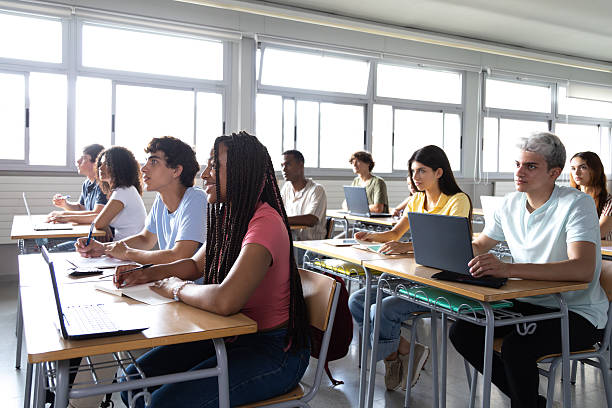 istock University students taking notes and following a lecture in classroom 2202469349