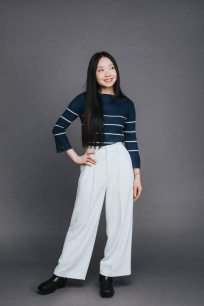 istock Cheerful Asian woman posing on a grey background 2202469590