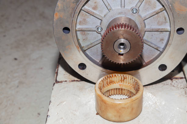 A removed electric motor with a gear on its shaft.