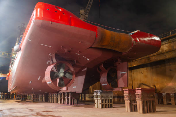 istock A ship standing in a dry dock at night under the light of lanterns. 2202472306