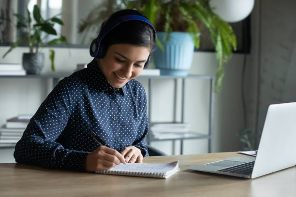 istock Smiling female in headphones talk on video call 2202472439