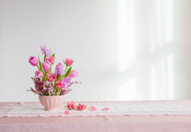 istock pink flowers in vase on background white wall 2202472482