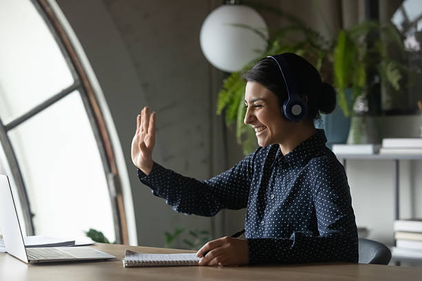istock Smiling Indian girl wave talking on video call 2202472511