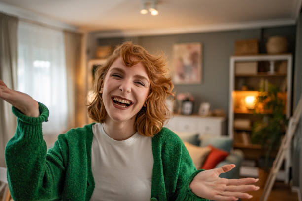 istock Cheerful young woman laughing and gesturing at home 2202472625