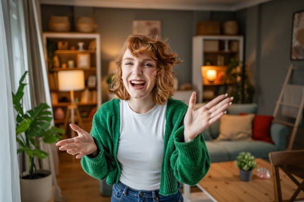 istock Young woman laughing and gesturing while standing in living room 2202472717