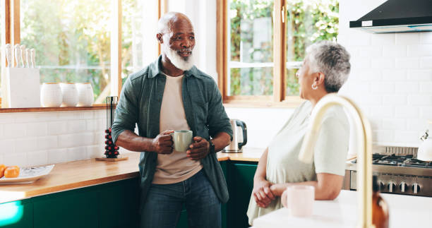 istock Senior, couple and talking with coffee in kitchen for communication, morning start and bonding together. Elderly people, discussion and caffeine drink for wellness, affection and retirement at house 2202474463