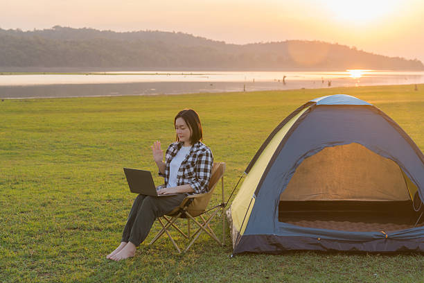 istock Freelance woman working on laptop while camping outdoors 2202474745