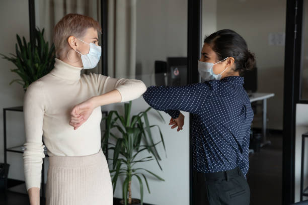 istock Female colleagues greeting in office touching elbows 2202478144