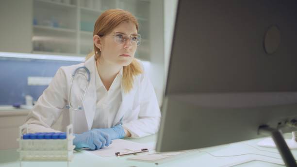 istock The laboratory employee compares the data from the survey with the document on the computer. 2202478429