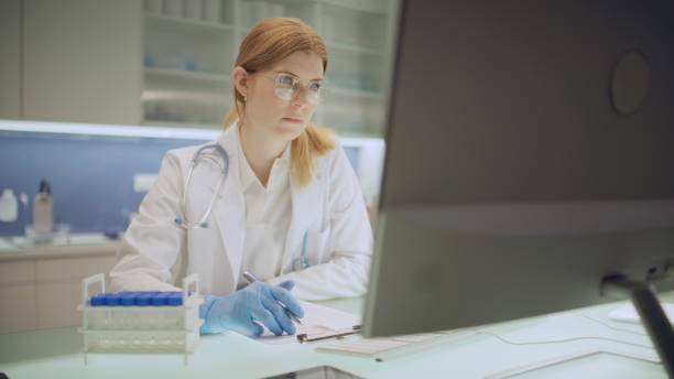 istock The laboratory employee compares the data from the survey with the document on the computer. 2202478505