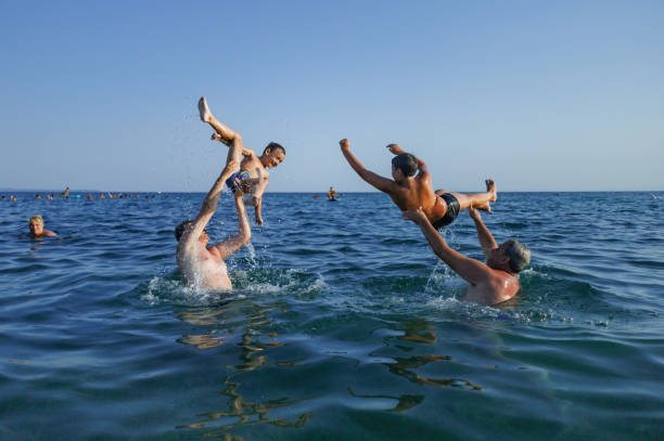 Fathers tossing the kids up into the sky and watching them soar before they land in the refreshing sea