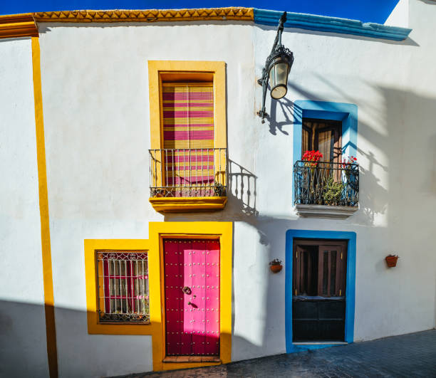 istock whitewashed facades with coloured windows and doors in a village street decorated with pots and plants. Nijar. Almeria 2202480185