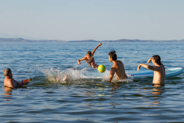 istock Kids Playfully Diving into the Sea 2202481225