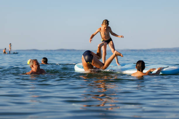 istock Dad and Kids Playing on a Floating Board 2202481410
