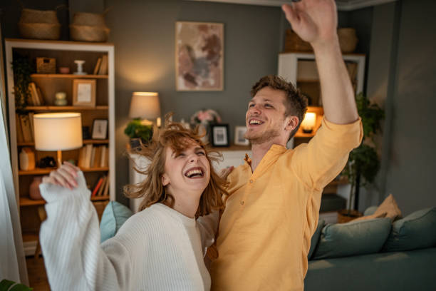 istock Young couple dancing and having fun at home 2202488752
