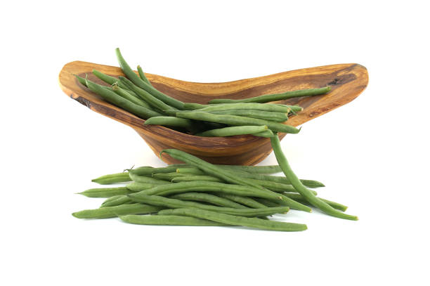 A collection of fresh green beans arranged in a rustic wooden bowl, isolated on white background. Perfect for concepts of natural food, freshness, and vegetarian cuisine.
