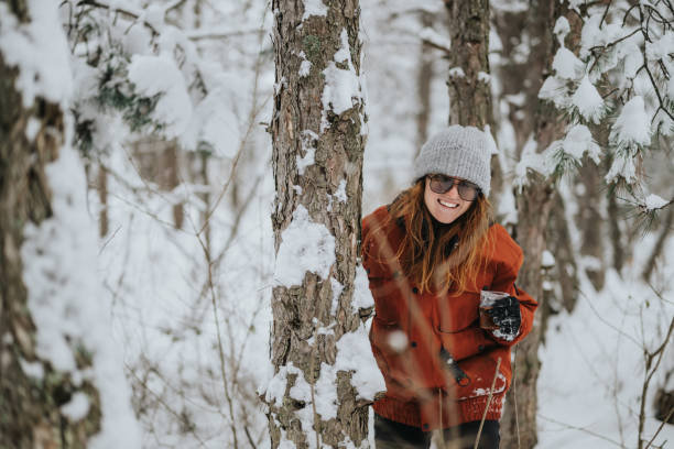 istock Woman enjoying winter outdoors surrounded by snow-covered trees in a forest 2202498075