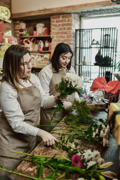 istock Female Employees Making Creative Chaos on Table at Flower Shop While Arranging Bouquets 2202506299