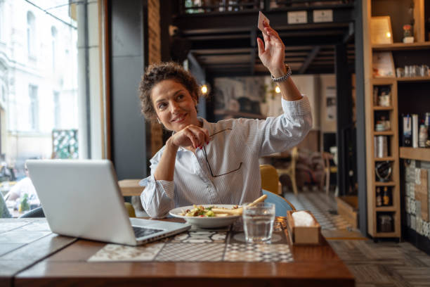 istock Smiling freelancer paying contactless with card in restaurant after work 2202506718