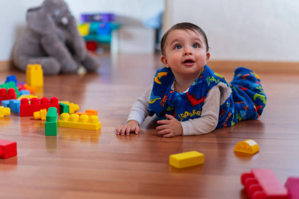 istock A very happy baby morning at home wearing his sleeping bag while smiling 2202507063