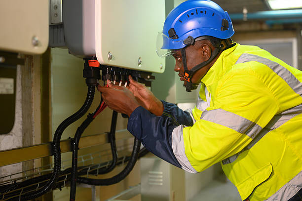 istock engineering technician Setting up the solar panel inverter in the electrical room Service engineer installs solar cells on factory roofs Concept of clean energy and renewable energy 2202509259
