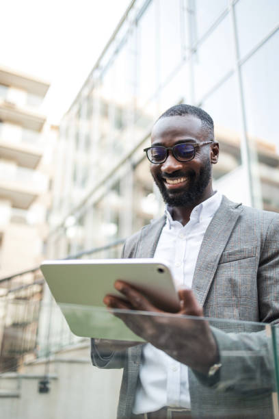 istock Businessman in smart casual attire using tablet outdoors at office 2202516833