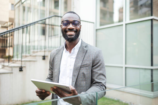 istock Confident businessman with tablet in modern urban setting 2202516842