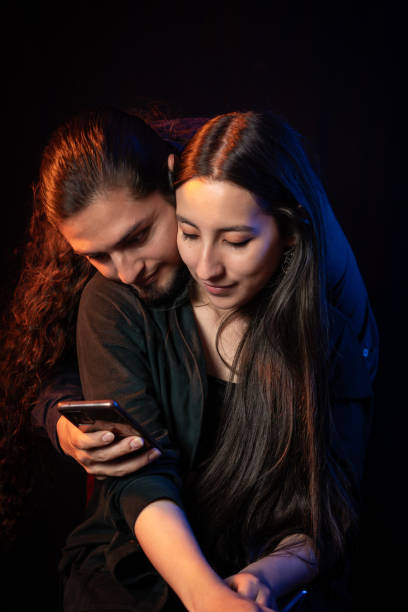 istock Affectionate couple looking at smartphone together in intimate pose 2202518952