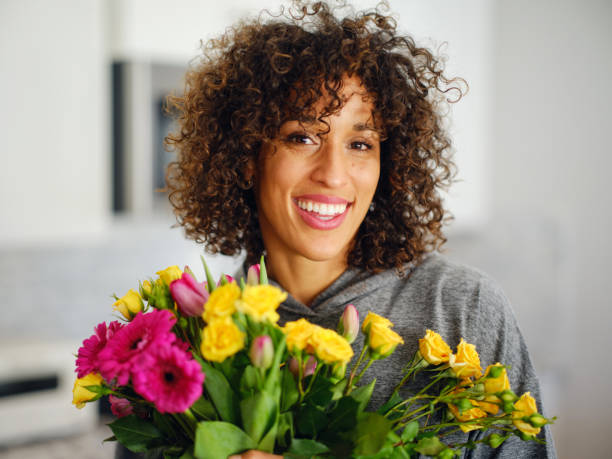 istock Woman in a Home With Fresh Flowers 2202519832