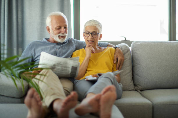 istock Mature couple reading magazines at home. 2202519929
