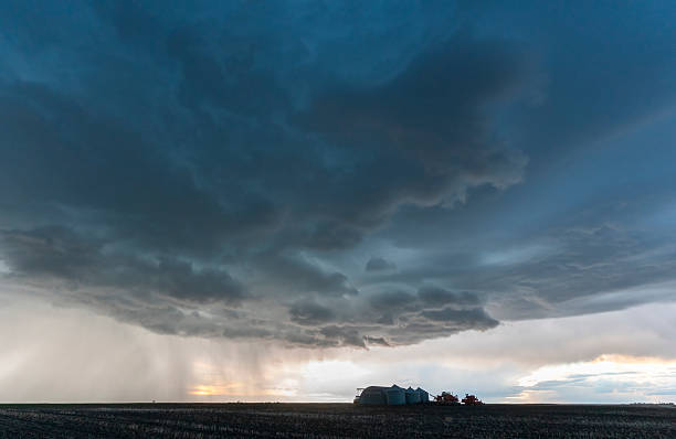 istock Dramatic supercell thunderstorm looming over a farm at sunset 2202524302